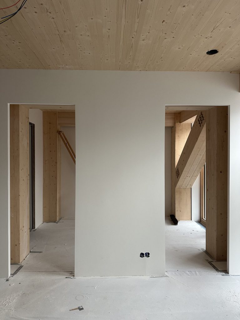 Afgewerkte binnenwanden naast de houten gebouwstructuur
