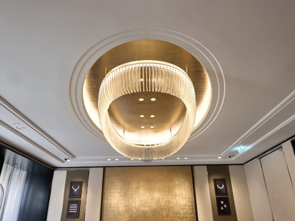 Bladgoud op het gipsplafond rond de ellipsvormige kroonluchter bij Van Cleef & Arpels Amsterdam